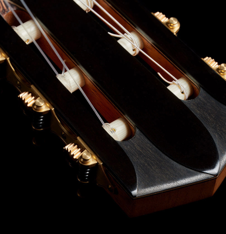 The carved headstock and tuning machines of a 2024 Elias Bonet classical guitar made of cedar and African rosewood