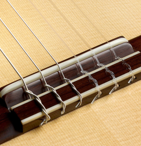 The bridge, tie-block and saddle of a 2025 Elias Bonet classical guitar made of spruce and green ebony