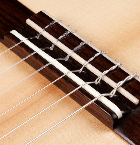 The bridge, tie-block and saddle of a 2024 Elias Bonet classical guitar made of spruce and maple