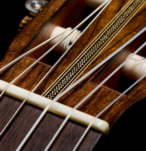 The nut and head veneer inlay of a 2026 Eduardo Bossa classical guitar made of cedar and ovangkol