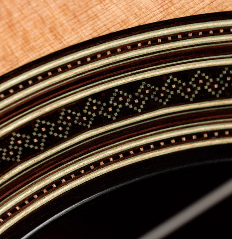 A close-up of the rosette of a 2023 Amélie Bouvret classical guitar made of cedar and figured mahogany.