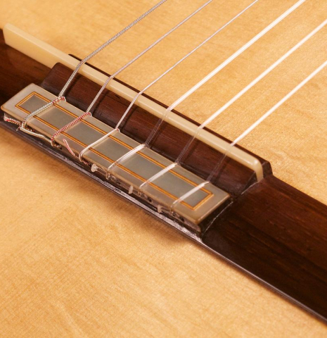 The bridge and tie block of the 2012 Tobias Braun classical guitar made with bearclaw German spruce and satinwood.