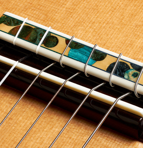 The bridge, tie-block and saddle of a 2019 Greg Brandt classical guitar made of cedar and CSA rosewood