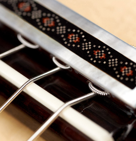 The tie block of a 2023 Kenneth Brogger classical guitar made of spruce and maple.