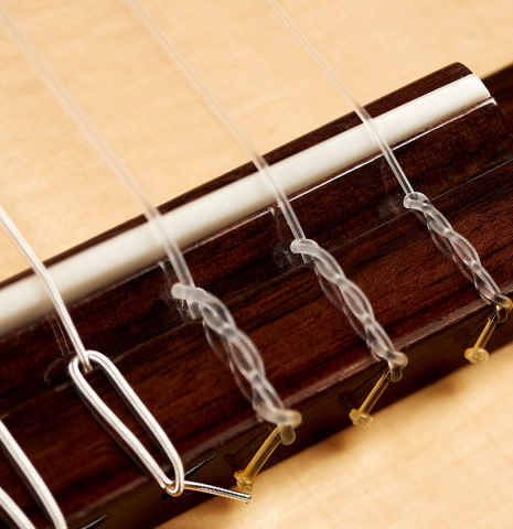 This is the bridge, tie-block and saddle of a 2023 Kenneth Brogger "1890 Torres" w/pegs classical guitar made of spruce and cypress