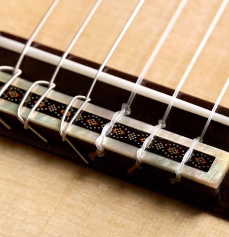 The bridge, tie-block and saddle of a 2020 Kenneth Brogger "Stradivarius" classical guitar made of spruce and CSA rosewood