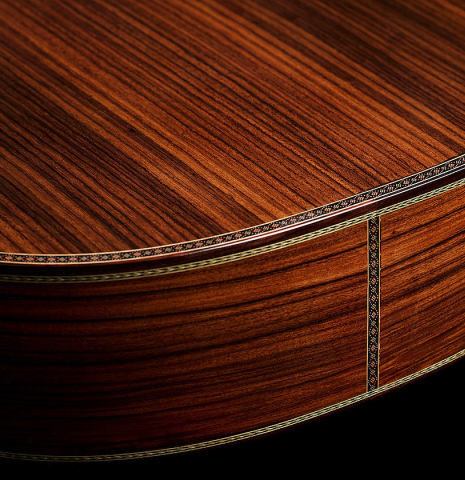 The back binding and mosaic purfling of a 2025 Kenneth Brogger "Mosaic" classical guitar made of spruce and Indian rosewood