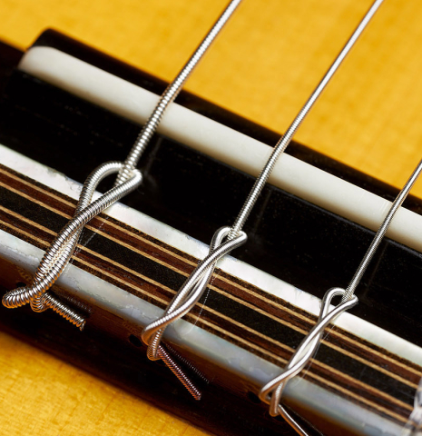 The bridge, tie-block and saddle of a 2023 Ivan Bruna "Limited Edition" classical guitar made of spruce and Indian rosewood