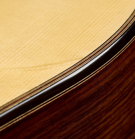 The top binding and purfling of a 2025 Ivan Bruna classical guitar made of spruce and Indian rosewood