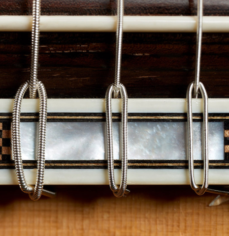 The bridge, tie-block and saddle of a 2002 Geza Burghardt "Grand Concert - dedicated to JL Romanillos" classical guitar made of spruce and CSA rosewood