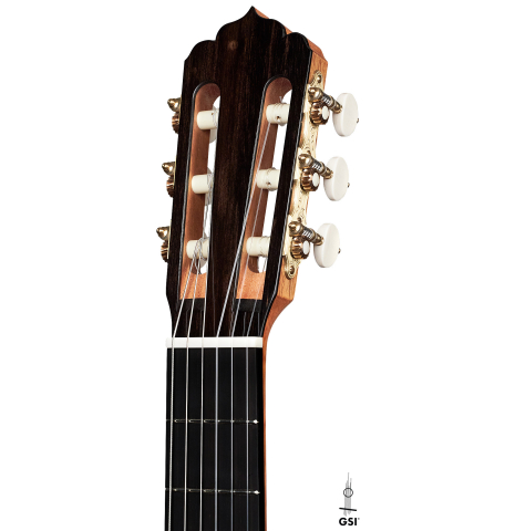The headstock of a 2023 Carlos Juan Busquiel classical guitar made with cedar and CSA rosewood shown on a white background