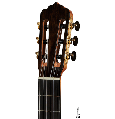The headstock of a 2024 Carlos Juan Busquiel classical guitar made with cedar and CSA rosewood shown on a white background