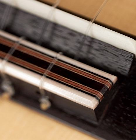 The tie block of a 2022 Michael Cadiz "Torres/Romanillos" classical guitar made with spruce and African rosewood.