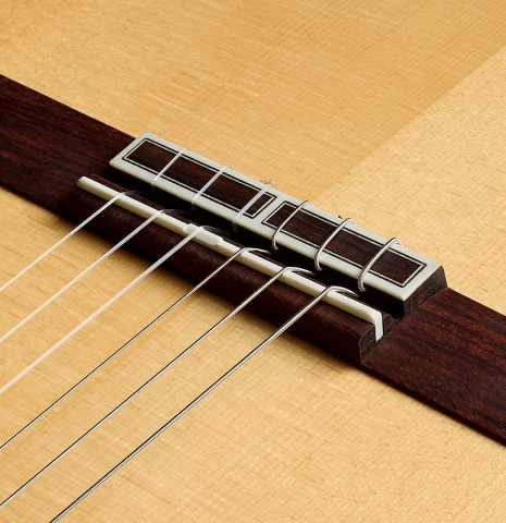 The bridge, tie-block and saddle of a 2026 Hermanos Camps "CL20-S" classical guitar made of spruce and exotic ebony