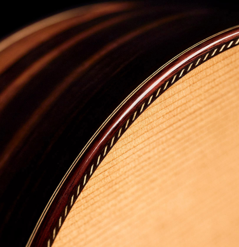 The purfling and binding of a 2023 Hermanos Camps "CL20-C" classical guitar made of cedar and exotic ebony.