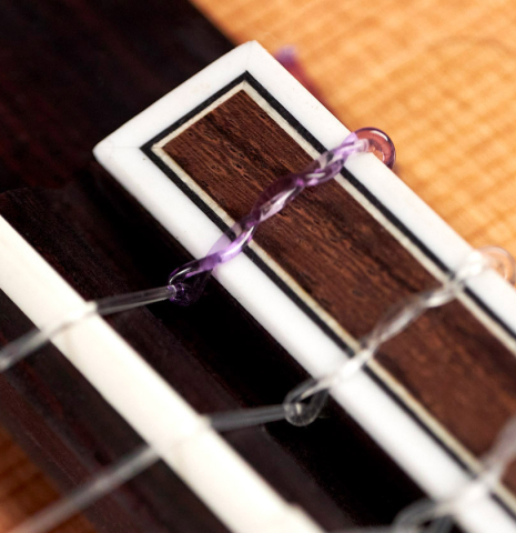 The tie block of a 2023 Hermanos Camps "CL20-C" classical guitar made of cedar and exotic ebony.