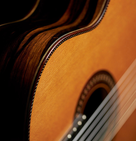The soundboard and side of a 2023 Hermanos Camps "CL20-C" classical guitar made of cedar and exotic ebony