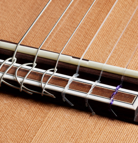 The bridge, tie-block and saddle of a 2025 Hermanos Camps "CL20-C" classical guitar made of cedar and exotic ebony