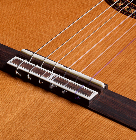 The bridge, tie-block and saddle of a 2026 Hermanos Camps "CL20-C" classical guitar made of cedar and exotic ebony