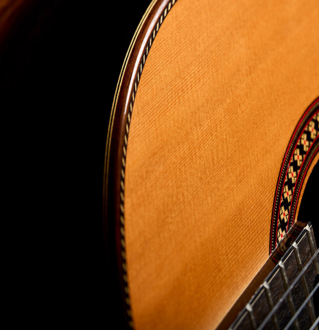 Side view of the treble side and top of a 2026 Hermanos Camps "CL20-C" classical guitar made of cedar and exotic ebony