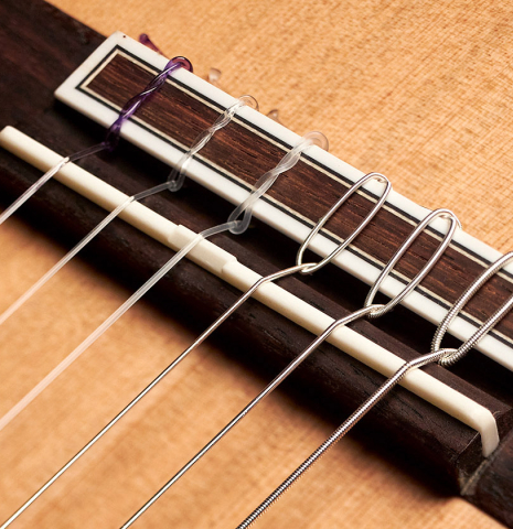 The bridge of a 2023 Hermanos Camps "GL18C" classical guitar made with cedar and Indian rosewood.