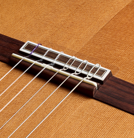 The bridge, tie-block and saddle of a Hermanos Camps "CL18C" classical guitar made of cedar and Indian rosewood
