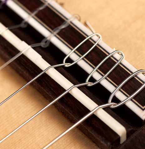 The bridge of a 2023 Hermanos Camps "GL18S" classical guitar made with spruce and Indian rosewood.