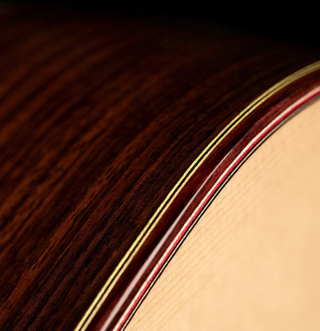 The binding of a 2023 Hermanos Camps "GL18S" classical guitar made with spruce and Indian rosewood.