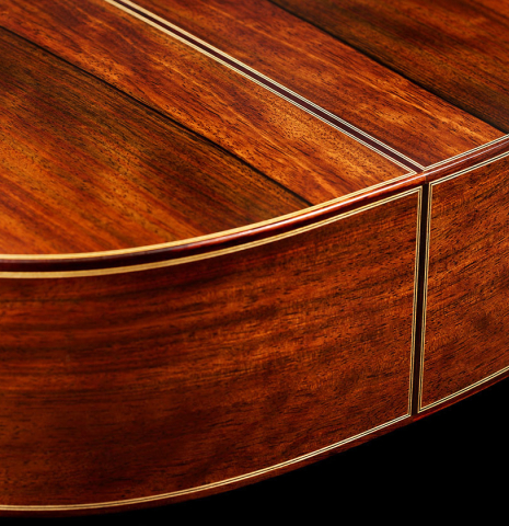 The sides and back at the foot of a 2024 Hermanos Camps "CL20-S" classical guitar made of spruce and Malaysian blackwood