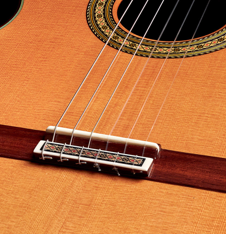 The bridge and saddle of a 2022 Vicente Carrillo "Primera Especial" classical guitar made with cedar top and African rosewood back and sides
