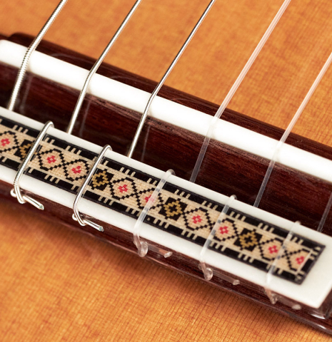 The bridge and saddle of a 2023 Vicente Carrillo "Primera Especial" classical guitar made with cedar top and African rosewood back and sides