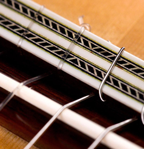 The close-up of the bridge and saddle of a Vicente Carrillo "India Estudio" made with spruce and Indian rosewood