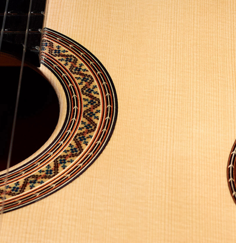 The spruce soundboard and rosette of a 2022 Vicente Carrillo "Maestro Double Top" classical guitar made with maple back and sides