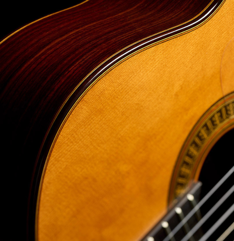 The top binding and purfling of a 2024 Vicente Carrillo "Herencia" classical guitar made of cedar and Indian rosewood