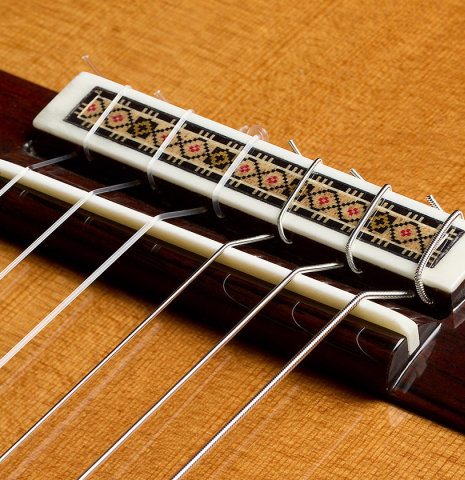The bridge, tie-block and saddle of a 2025 Vicente Carrillo "Primera Especial" classical guitar made of cedar and Malaysian blackwood