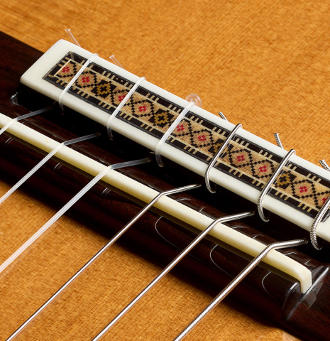 The bridge, tie-block and saddle of a 2025 Vicente Carrillo "Primera Especial" classical guitar made of cedar and Malaysian blackwood