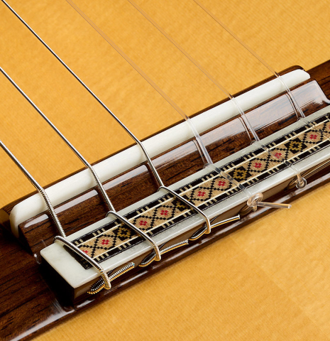 The bridge, tie-block and saddle of a 2025 Vicente Carrillo "Primera Especial" classical guitar made of spruce and Malaysian blackwood