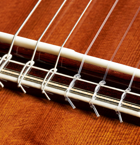 The bridge, tie-block and saddle of a 2023 Gerardo Centonze classical guitar made of cedar and African rosewood