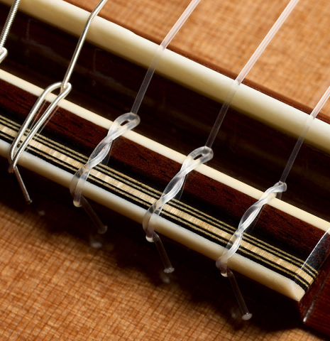 The bridge, tie-block and saddle of a 2025 Gerardo Centonze classical guitar made of cedar and African rosewood