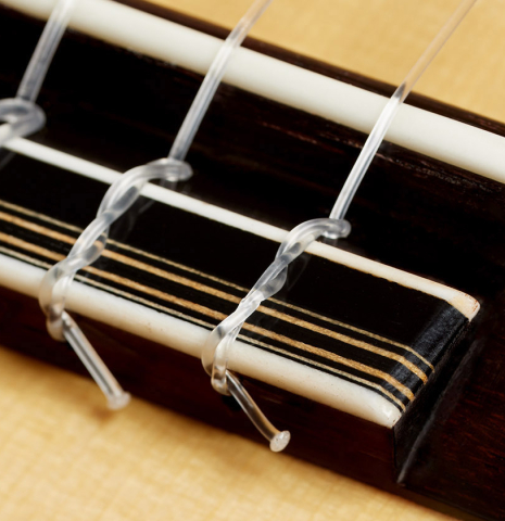 The bridge, tie-block and saddle of a 2024 Gerardo Centonze classical guitar made of spruce and Indian rosewood