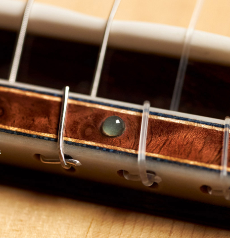 The tie block and aquamarine ornament of a 2023 Moonseok Choi classical guitar made with spruce and African rosewood.