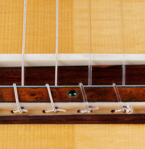 The bridge, tie-block and saddle of a 2024 Moonseok Choi "Nomad" classical guitar made of spruce and African rosewood