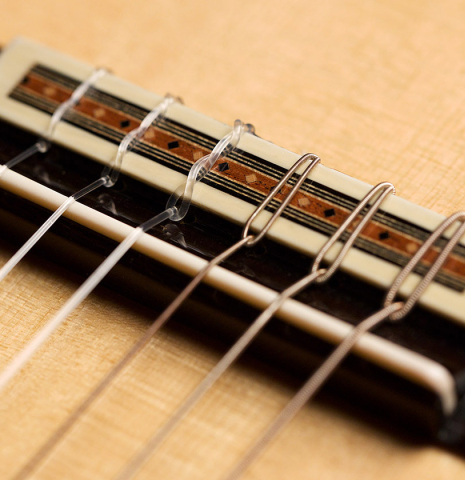 The bridge and saddle of a 2001 Brian Cohen classical guitar made with spruce and CSA rosewood