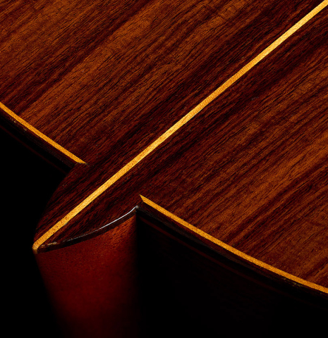 The heel, back binding and purfling of a 1990 Brian Cohen classical guitar made of spruce and Indian rosewood