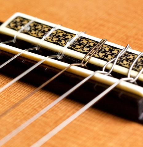 The bridge, saddle and nylon strings of a 2003 Manuel Contreras II "Double Top" CD/CSAR (ex Pepe Romero) classical guitar