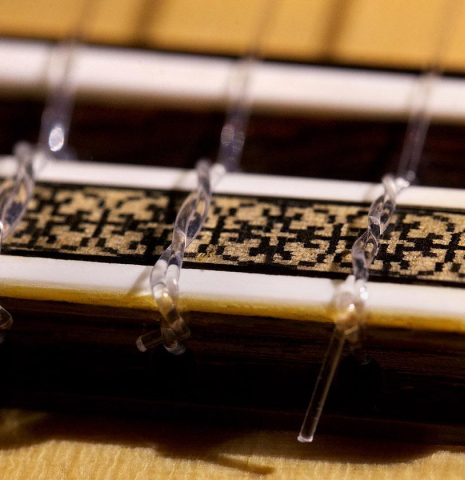 The bridge, tie-block and saddle of a 2005 Manuel Contreras II "Double Top" classical guitar made of spruce and CSA rosewood