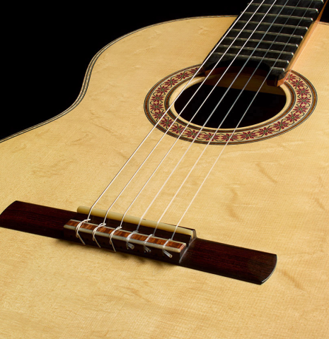 The soundboard and bridge of a 2016 Stephan Connor "640" classical guitar made of spruce and koa
