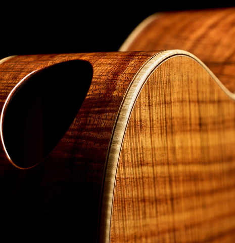The side soundport of a 2016 Stephan Connor "640" classical guitar made of spruce and koa