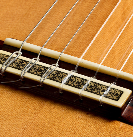 The bridge, tie-block and saddle of a 2010 Manuel Contreras II "1a Especial" classical guitar made of cedar and CSA rosewood