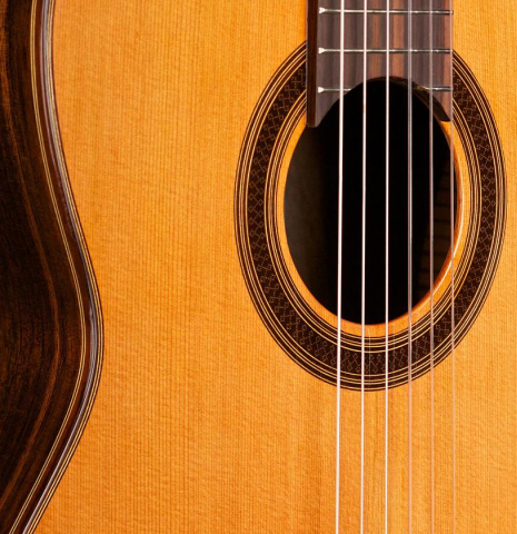 The soundboard, rosette and side of a Cordoba "C7" classical guitar made with cedar top and Indian rosewood back and sides